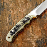 The handle is crafted from deeply engraved camel bone, presenting a striking wildlife scene that flows naturally along the handle’s curved profile.