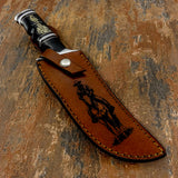 The handcrafted leather sheath continues the frontier theme with a deeply engraved image of a cowboy riding his horse across open terrain.