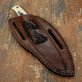 The genuine brown leather sheath is custom-fitted and deeply engraved with a detailed elk scene. The