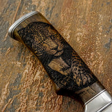 Wooden handle with leopard engraving on a wooden surface