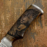 Knife handle with a detailed leopard engraving on a textured brown background