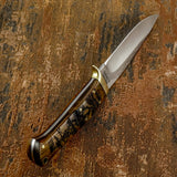 The rosewood handle scales feature deep engraving depicting a U.S. Navy warship cutting through ocean waves, with the ship’s mast