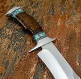 A close-up of a custom knife with a polished D2 blade, a contoured brown Burl wood handle, and turquoise inlay accents