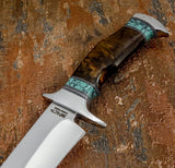 A close-up of a fixed-blade knife with a polished D2 blade and a decorative handle made of dark brown wood and turquoise inlay