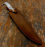 Contrasting stitching runs around the perimeter, while a retaining strap with metal snap helps keep the knife securely seated.
