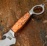 A close-up of a fixed-blade knife with a polished silver D2 steel blade and handle, featuring a vibrant orange Gemstone handle. 