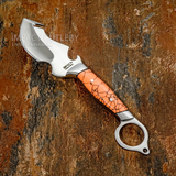 The satin-finished D2 Tool Steel blade features a deeply contoured profile with pronounced sweeping curves and integrated hook details. The unusual geometry is complemented by a substantial finger-ring pommel, giving the knife a highly individual silhouette.