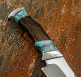 A close-up of a custom knife handle with a dark wood grip and turquoise GemStone inlay sections