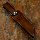 A brown leather knife sheath with white stitching and silver rivets