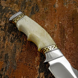 Closeup of the knife handle Beautifully contoured ergonomic bone handle, intricate brass filework details, slim profile handle with finger notches