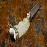 A custom knife from UK Store with a textured ivory bone handle and gold-toned geometric inlays