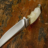 A close-up of the curved blade of Sandstone Knife with a satin-finished D2 blade, a cream-colored bone handle, and gold-toned geometric metal accents, Buy from UK Knife store.