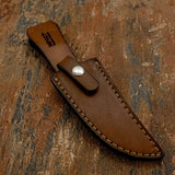 A brown leather knife sheath with contrasting cream color stitching and a silver snap button for Sandstone Knife, available from UK knife shop