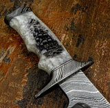 The handle is crafted from polished pearl resin, showcasing natural marbling, soft tonal variation, and a luminous finish that shifts subtly in different lighting. 