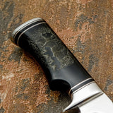 The handle is crafted from deeply engraved bull horn, displaying rich natural tones that transition from dark charcoal to lighter smoky shades across the surface.