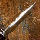 A close-up of a fixed-blade Survival knife with Sawtooth spine and sharpened top swedge.