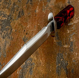 A close-up of a large fixed-blade Survival knife with Sawtooth spine and sharpened top swedge.