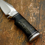 Fine engraved lines create detailed fur textures and subtle ground elements, giving depth and movement to the scene as it follows the natural curvature of the handle.