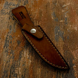 A brown custom leather knife sheath with visible stitching and a silver snap button. UK Knife shop