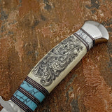 The handle combines camel bone with turquoise-coloured gemstone accents, separated by fine contrasting spacers. The cream-toned camel bone features elaborate flowing scrollwork that follows the curvature of the handle.
