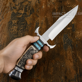 A hand holds a Custom Canyon Scroll Bowie Knife with a silver D2 blade, Engraved Bone, turquoise and black inlay handle, and Stainless Steel Guard and Pommel 