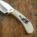 Fine engraved linework defines the cougar’s muscular form, facial features, and flowing movement, creating a realistic wildlife illustration across the handle’s smooth ivory-toned surface.