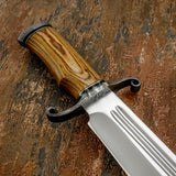 Close up of Kingsmarch Handmade Bowie knife with satin D2 steel blade, double fuller, wood handle and hand forge damascus guard
