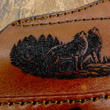 Fine engraved lines capture the wolves’ fur texture and posture while the surrounding trees and terrain create depth across the composition.