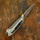 Polished pins secure the handle scales while complementing the organic character of the material, and the ergonomic curve of the handle offers a comfortable, balanced grip during use.
