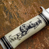 The handle is crafted from deeply engraved camel bone, showcasing a dramatic hunting scene that stretches along the length of the handle.
