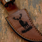 The design uses bold linework and shading to emphasize the elk’s stance and presence, creating a striking wildlife motif that complements the artwork engraved on the handle.