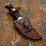 Reinforced stitching follows the sheath’s edges, while the snap-retention strap secures the knife safely during carry.