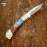 Decorative knife with a wooden handle on a textured brown background, featuring 'Impact Cutlery' branding.