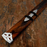 Wooden Sword handle with silver decorative elements on a textured brown background